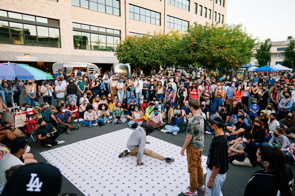 people at director park watching a break dancer