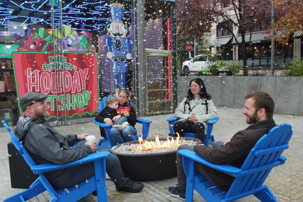 Group enjoying the fire pits while it snows at Director Park